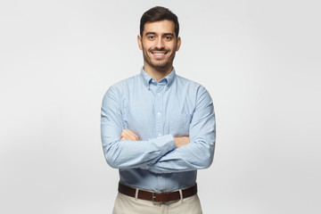 Handsome smiling business man in blue shirt isolated on gray background
