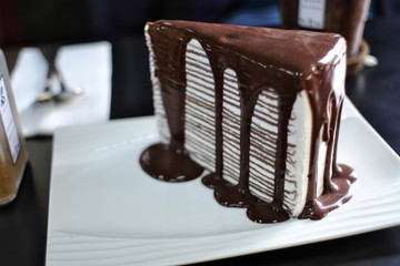 The hot cocoa on top is decorated with a swan shape, served with hot tea, placed on a wooden tray.