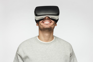 Virtual reality concept. Close-up studio portrait of smiling young man in VR glasses