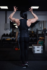 fitness girl resting and showing off her muscles in the gym.