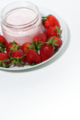 strawberry yogurt in glass jar and fresh berries on white background, vertical