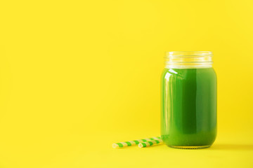 Bottle of green celery smoothie on yellow background. Banner with copy space. Fresh juice for detox. Vegan, alkaline healthy diet concept