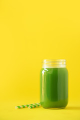 Bottle of green celery smoothie on yellow background. Banner with copy space. Fresh juice for detox. Vegan, alkaline healthy diet concept