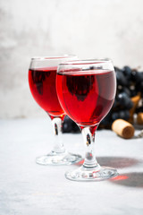 two glasses of red wine on a gray table