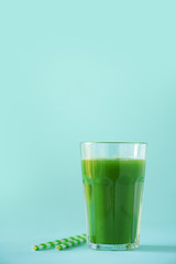 Glass of green celery smoothie on blue background. Banner with copy space. Fresh juice for detox. Vegan, alkaline healthy diet concept