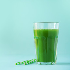 Glass of green celery smoothie on blue background. Banner with copy space. Fresh juice for detox. Vegan, alkaline healthy diet concept