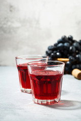 two glasses of red young wine on gray table, vertical