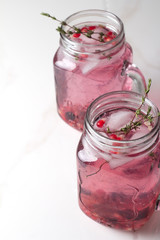 refreshing drink with pomegranate and thyme with ice and place for text.