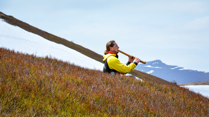 a musician plays the shakuhachi flute in the mountains
