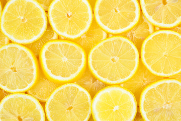 Obraz premium A slices of fresh juicy yellow lemons. Texture background, pattern.