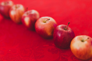 group of red apples on table cloth of the same color