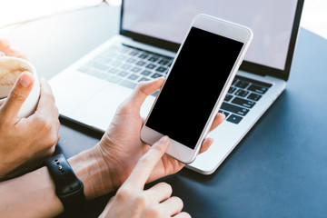 Young Asian woman using smartphone mock up blank black screen in cafe. Lifestyle women communication and working in coffee shop concept.