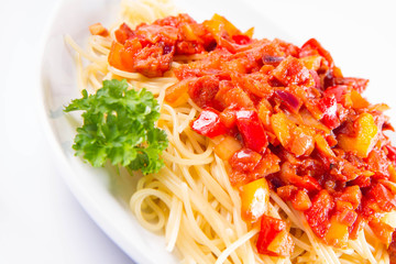 Spaghetti with sauce decorated with fresh parsley on a plate on a white background
