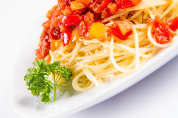 Spaghetti with sauce decorated with fresh parsley on a plate on a white background