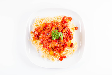 Spaghetti with sauce decorated with fresh parsley on a plate on a white background