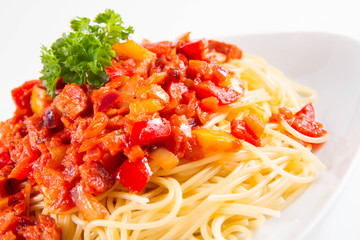 Spaghetti with sauce decorated with fresh parsley on a plate on a white background