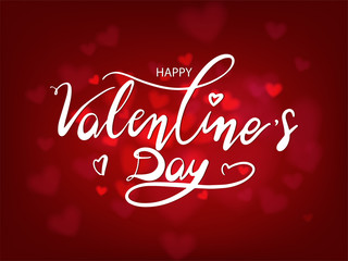 Fototapeta na wymiar White happy valentine's day lettering on red heart bokeh background