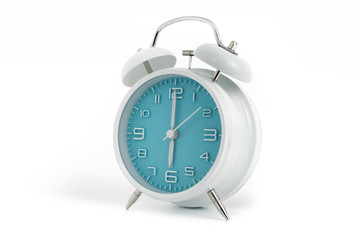 Twin bells analogue alarm clock with turquoise clock face shows six o’clock, 6 AM PM; concept on white background