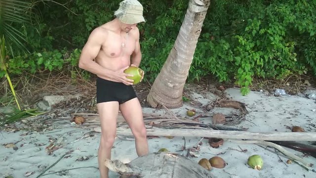 hungry man trying to open up coconut