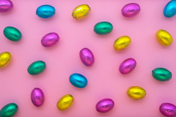 Easter eggs in colorful foil over pink, holiday background
