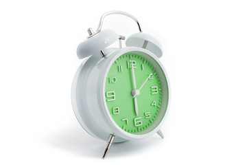 Twin bells analogue alarm clock with green clock face shows six o’clock, 6 AM PM; concept on white background