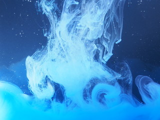 Fototapeta premium Blue paint is mixed with water. The dissolution of ink in water.