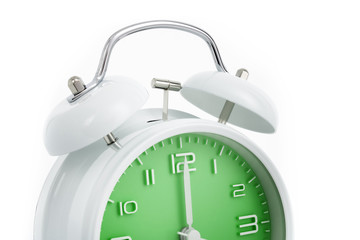 Cropped twin bells analogue alarm clock with green clock face shows completed hour, concept on white background