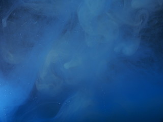 Blue paint is mixed with water. The dissolution of ink in water.