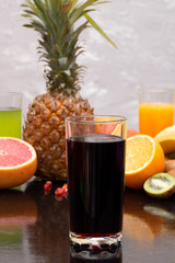 glass of pomegrante juice, blurred fruit background and 