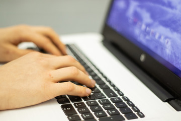 Man using laptop, searching web, browsing information, having workplace at home 