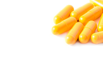 Bright yellow pills and blisters scattered on a white background. Isolated.