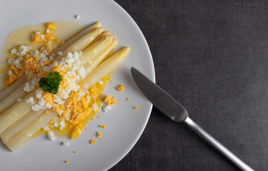 cooked white asparagus with butter and boiled eggs
