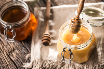 Honey in jars and  dipper on rustic oak table