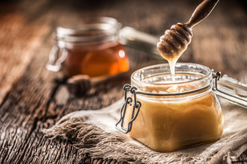 Honey in jars and  dipper on rustic oak table
