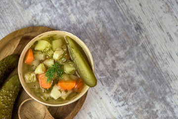 Vegetarian soup made of pickled cucumbers - light color of background - top view with space for text.