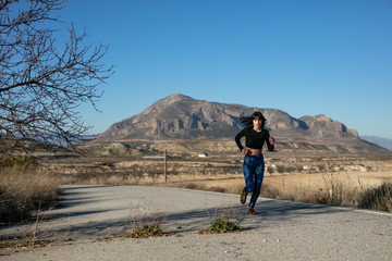 Young woman enjoys doing sport in the field