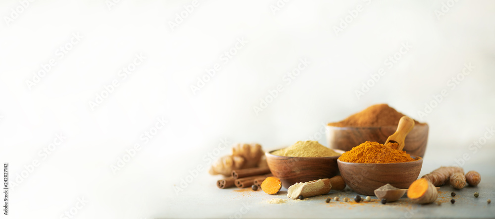 Wall mural ingredients for hot ayurvedic drink. turmeric powder, curcuma root, cinnamon, ginger, lemon over gre