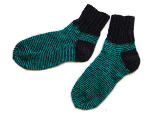 A pair of two black and green striped pattern handmade hand knitted warm wool winter socks isolated on the white background 