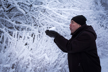 man blowing on snow