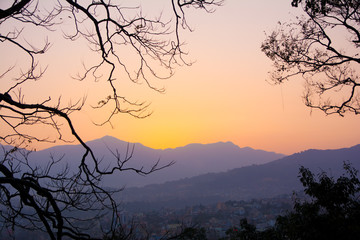 View of a sunset enclosed in a frame of trees to mean a concept of tourism