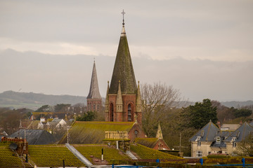 Shot showing various rooftops and church spire in worthing west susserx and the south downs on a...