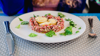 Raw red meat tartare on a plate in a restaurant