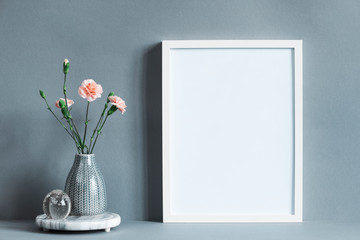 Stylish and minimalistic composition of mock up photo frame with flowers in vase. Modern concept of mockup frame. 