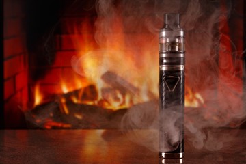 electronic cigarette within vapor on fireplace background