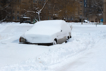 The car is covered with a thick layer of snow