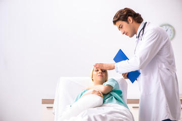 Obraz premium Young handsome doctor visiting female oncology patient 