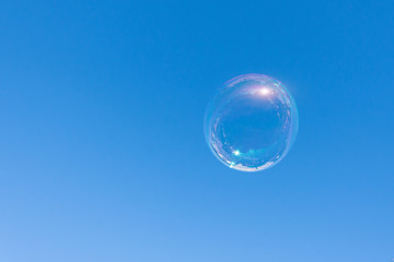 Alone soap bubble fly on blue sky background