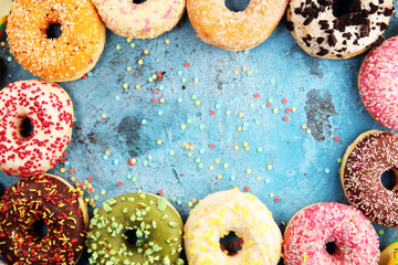 assorted donuts with chocolate frosted, pink glazed and sprinkles donuts