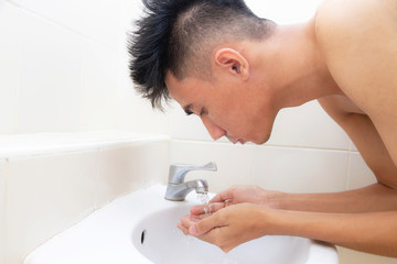Young man face wash sink bathroom