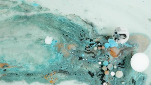 Colorful paint in bubbles organically moves in the liquid